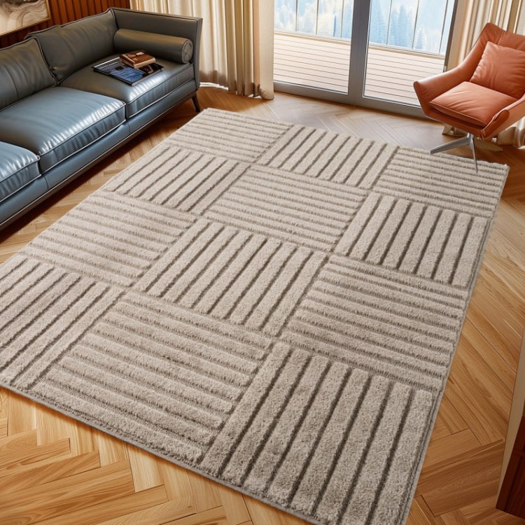 dywan-nowoczesny-3d-a-1123beige--art-kwadraty-beżowy-aranzacja-na-ciemnej-podlodze_w_jodełkę_z_fotelem_i_ciemną_sofą_z-oknem-balkonowym.jpg